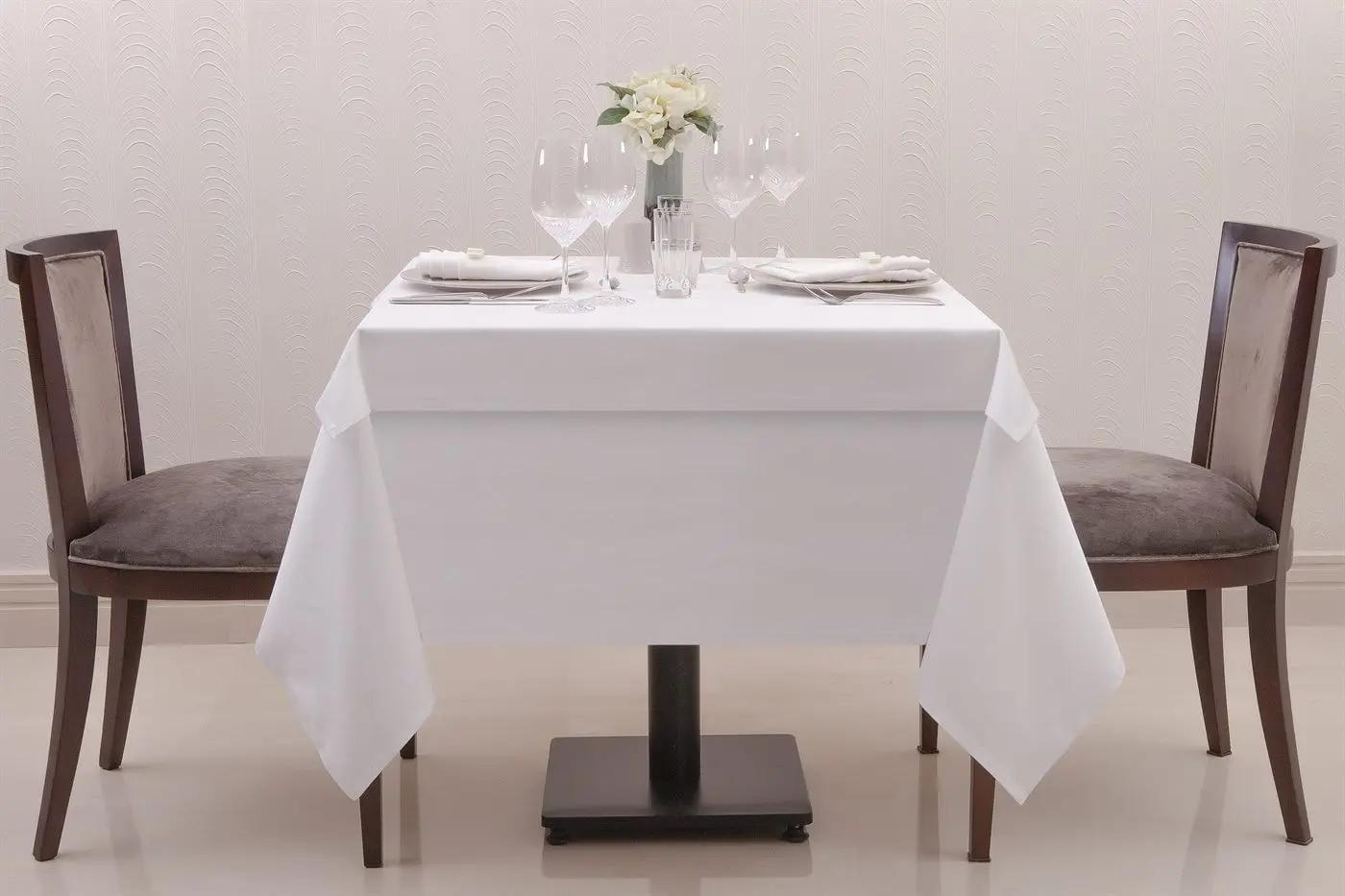 Beyaz masa örtüsü ve peçetelerle hazırlanmış restaurant masası